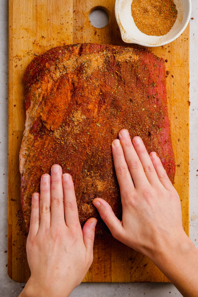 Coating beef brisket with spice mixture. 