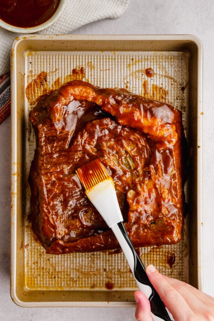 Brushing brisket with bbq sauce