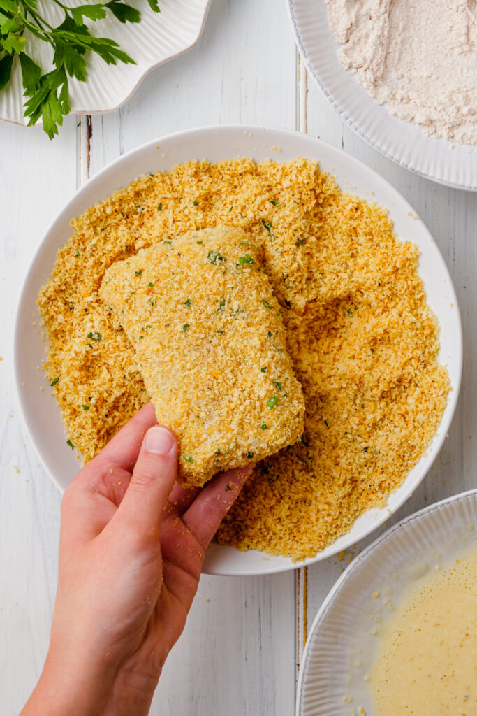 Dredging fish and coating in a crispy coating for an oven fried fish