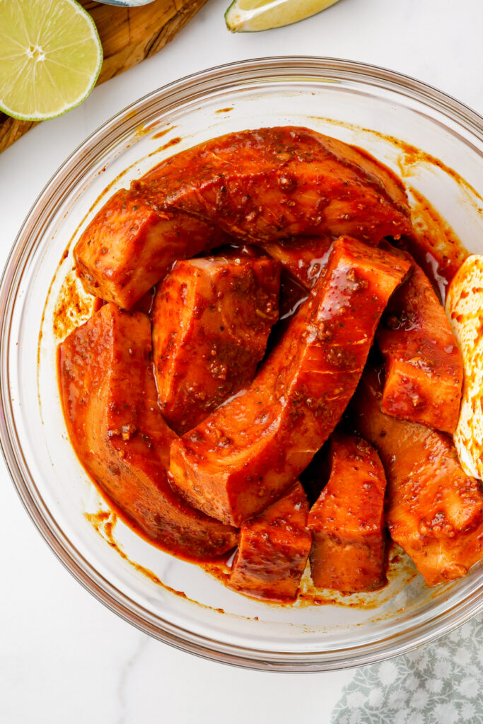 A bowl of swordfish coated in marinade, for grilled fish tacos