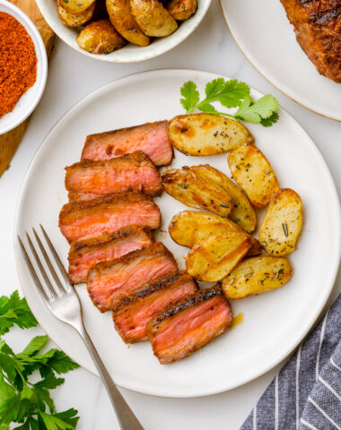 Sirloin steak with potatoes on a white plate