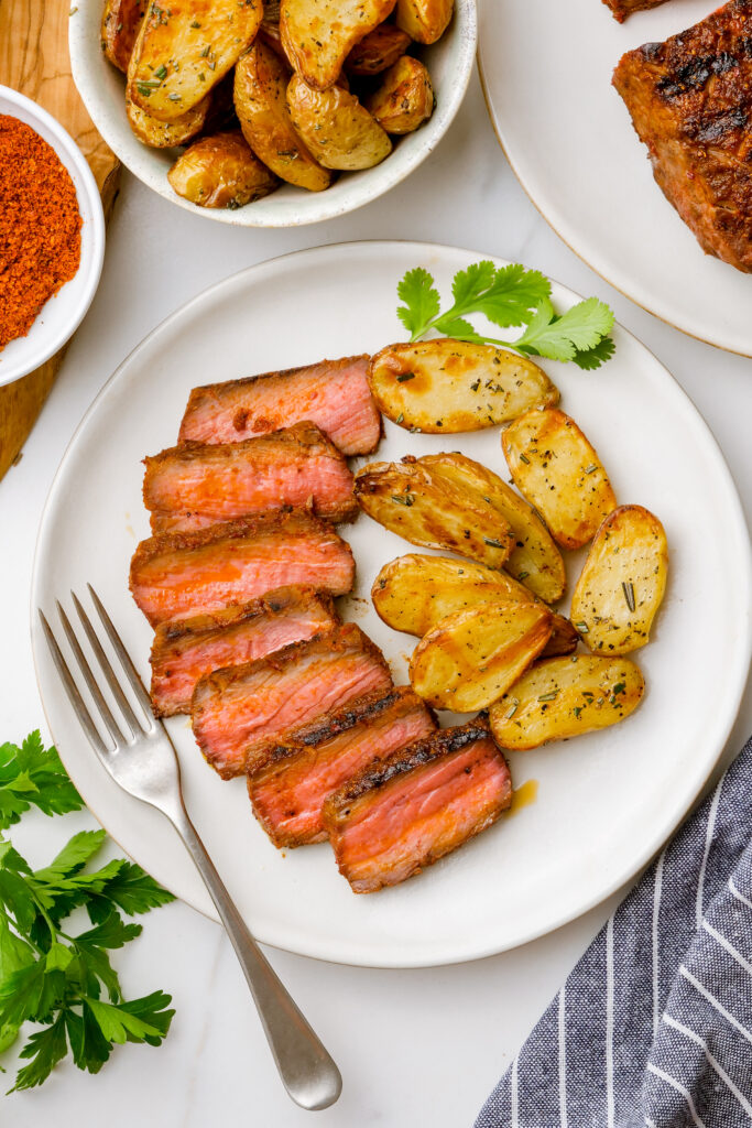 Sirloin steak with potatoes on a white plate