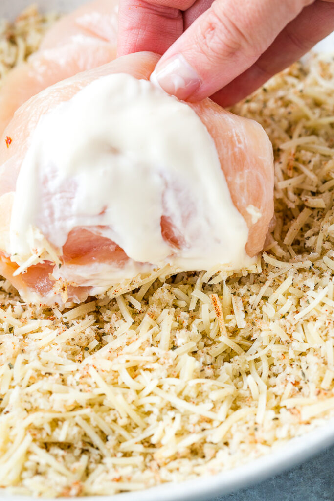 Pressing the chicken into the crumb mixture to make lemon basil chicken.