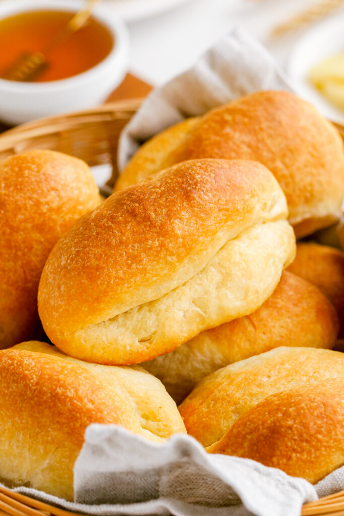 Parker house rolls stacked in a basket. 