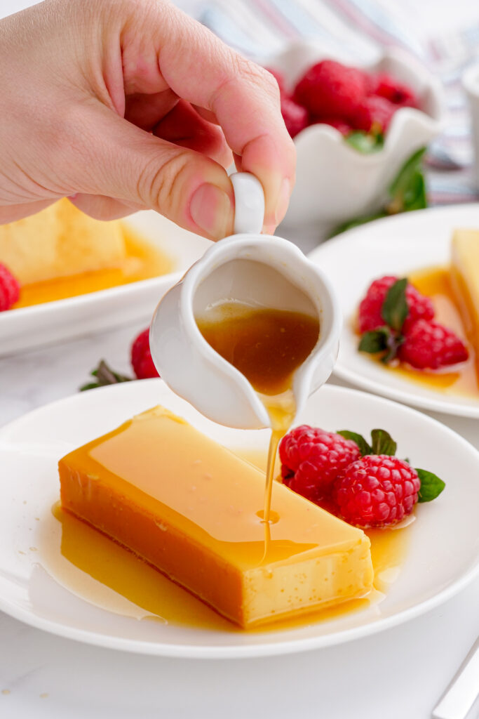 flan that is sliced and ready to be served, with additional caramel sauce