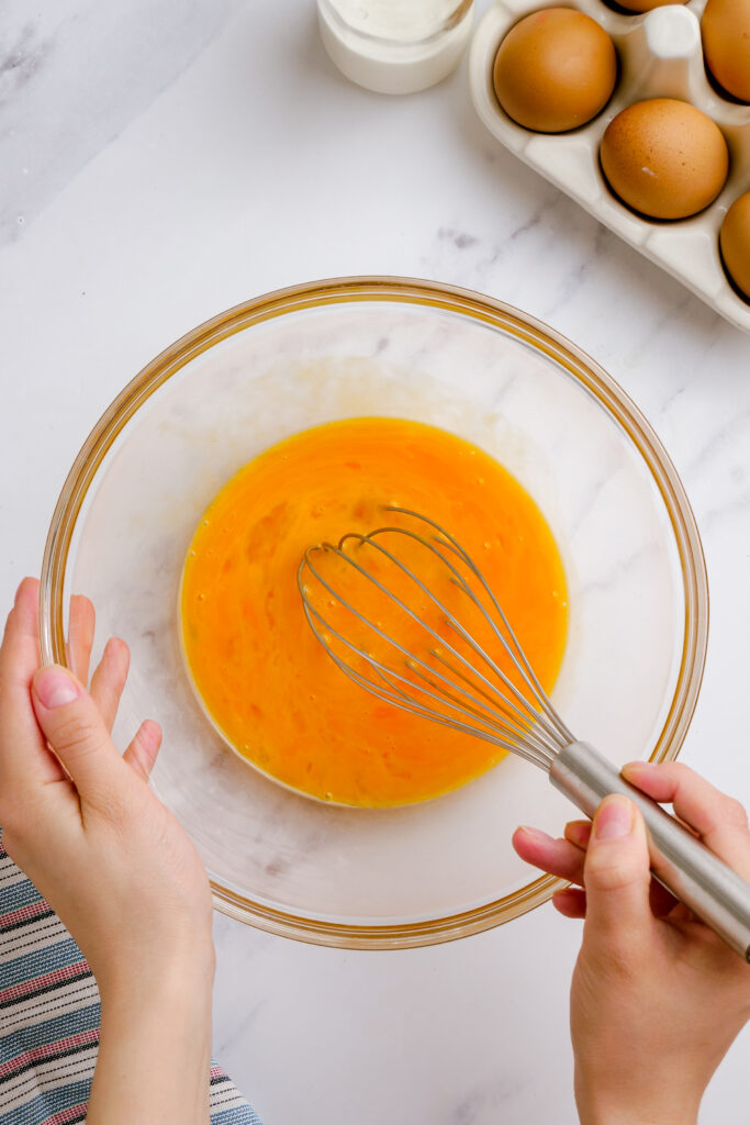 Mixing egg yolks in a bowl for flan