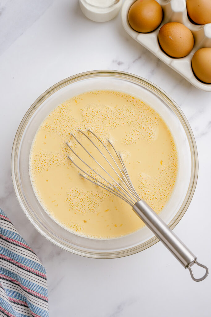 Whisking all the flan ingredients into a bowl