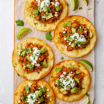 Platter of tinga tostadas, loaded with braised pork and a crispy tortilla