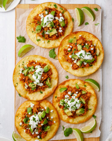 Platter of tinga tostadas, loaded with braised pork and a crispy tortilla
