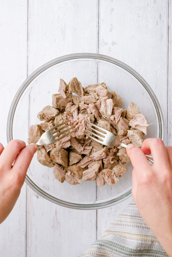 Shred pork with forks for tinga