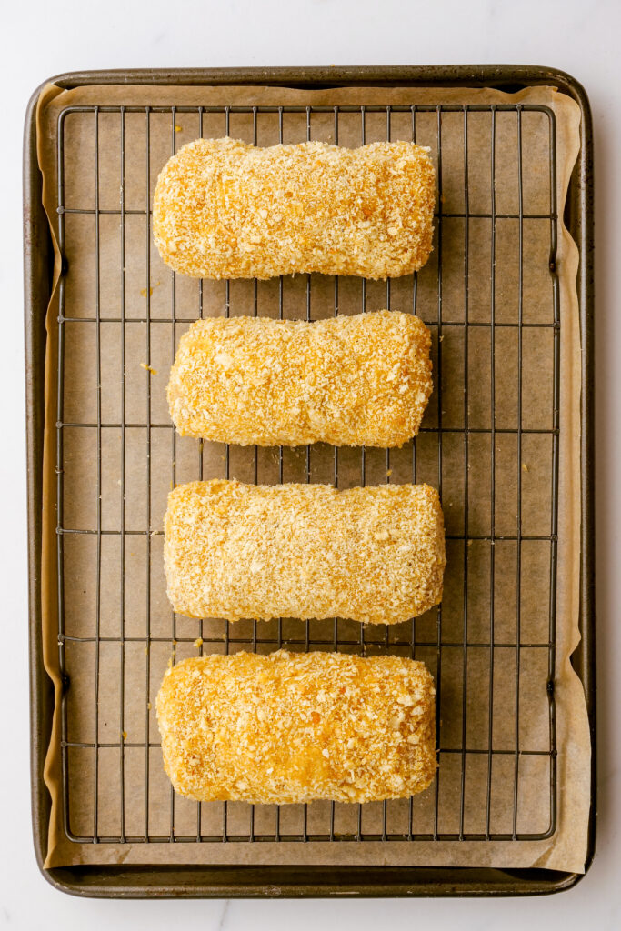 Placing chicken on a rimmed baking sheet, with bread crumbs
