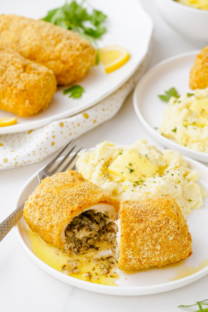 A delicious serving of chicken kiev, a baked and delicious chicken with herbed butter and a crispy exterior coating.