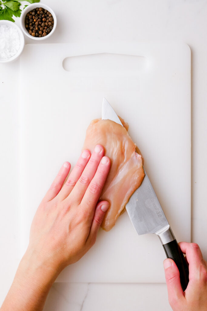 Making chicken kiev, pat chicken dry, season it, and slice it to make it thinner