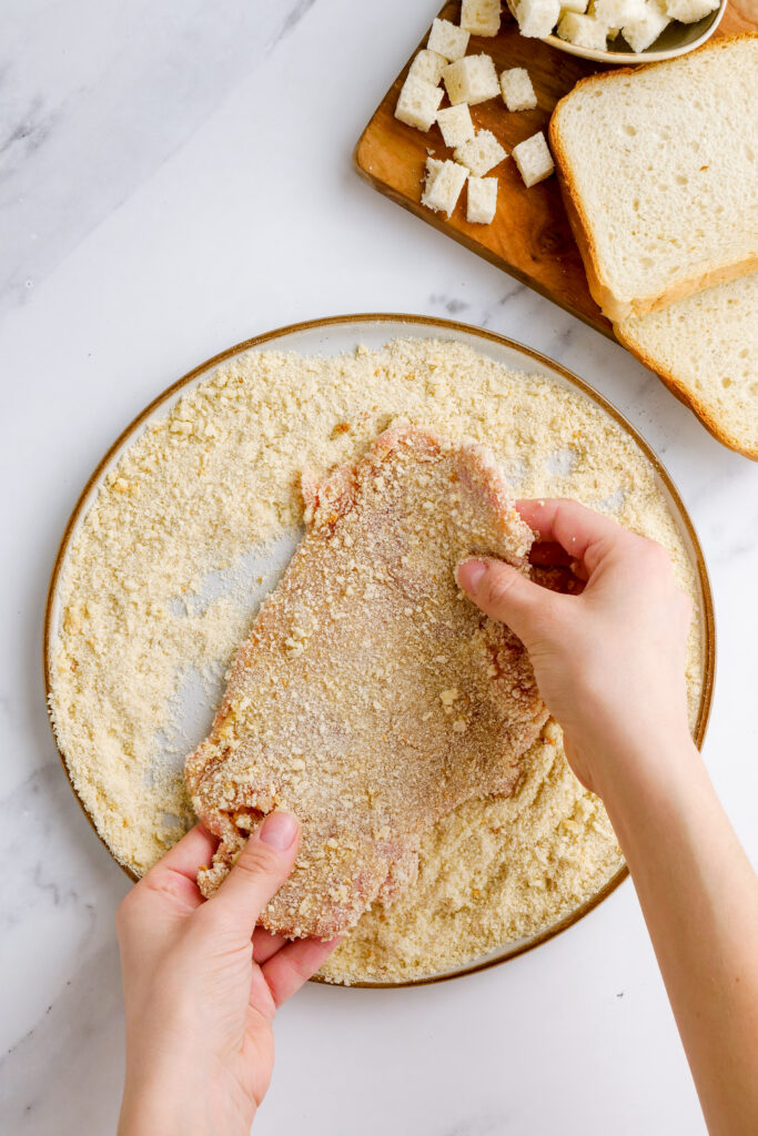 Making pork schnitzel, dredging in the three toppings of flour, eggs, and bread crumbs