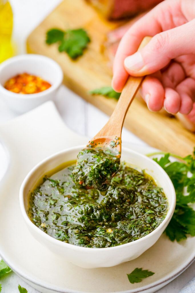 Chimichurri sauce in a bowl with a spoonful out