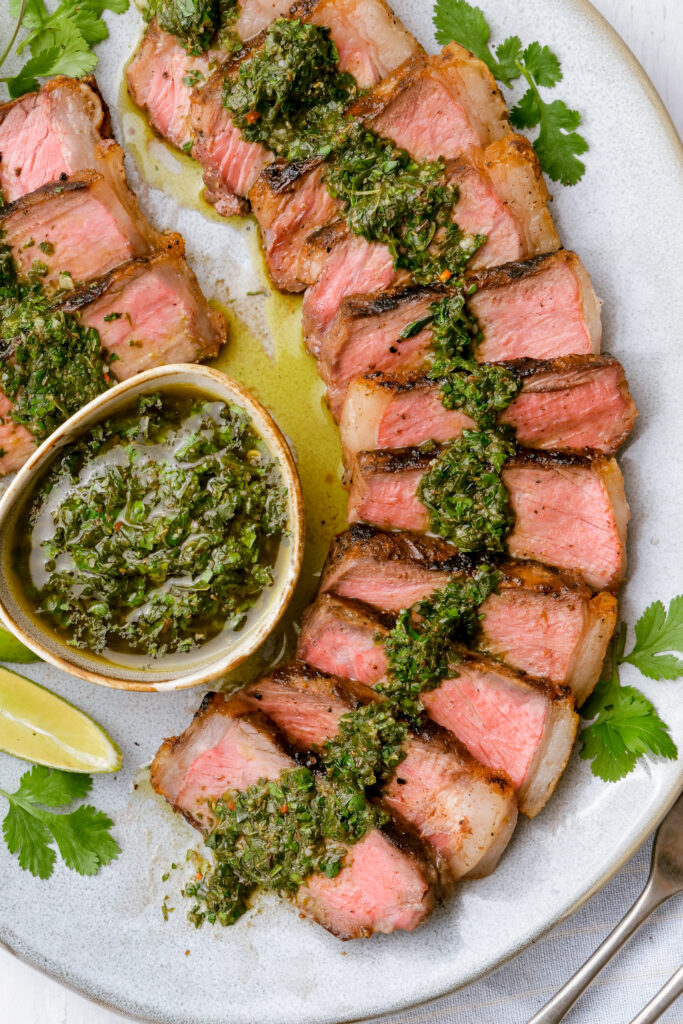 Steak with chimichurri sauce on a platter