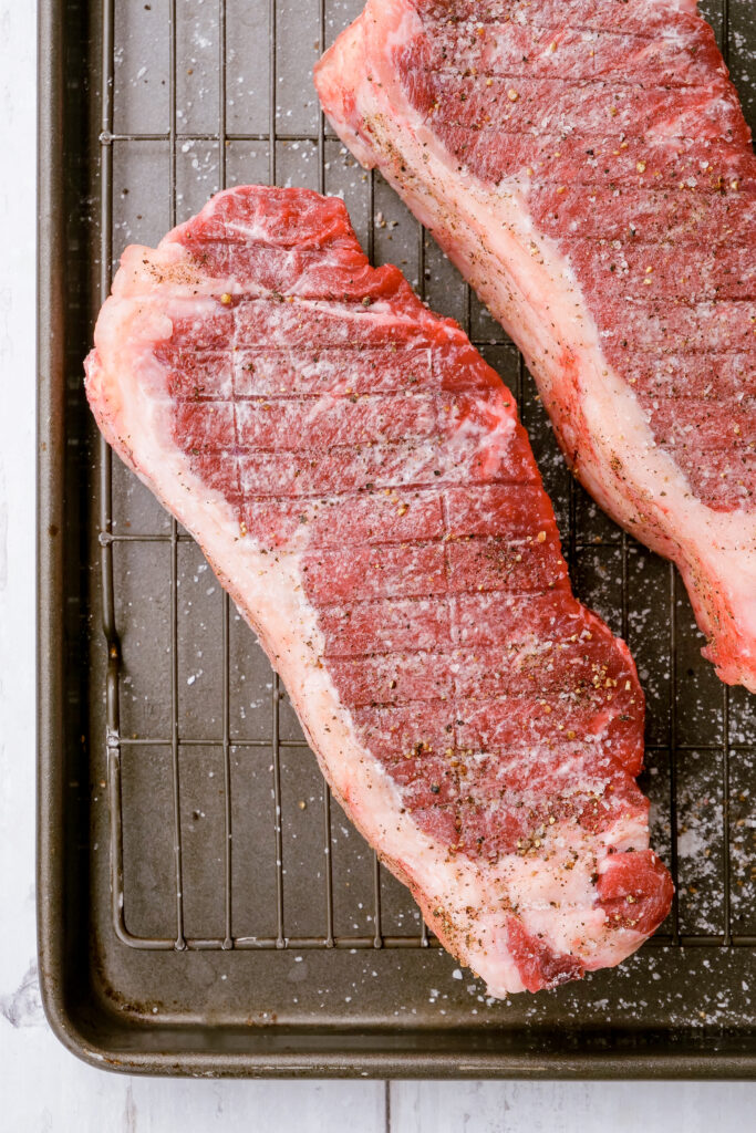 Coating the steaks for grilling with a cornstarch and salt mixture