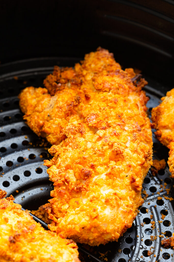 Air fryer chicken tenders coated in cheesy crackers