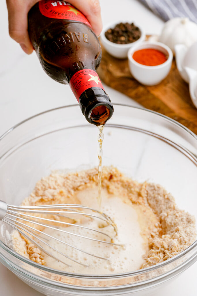 Adding the beer to the beer batter for crispy fried fish