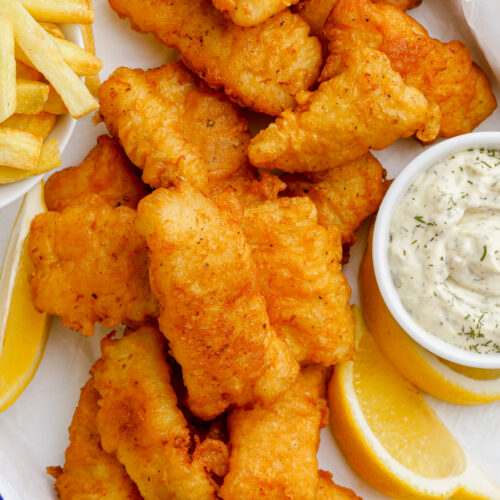 Crispy Beer Battered Fish Recipe, a bunch of fish on a platter with fries and tartar sauce