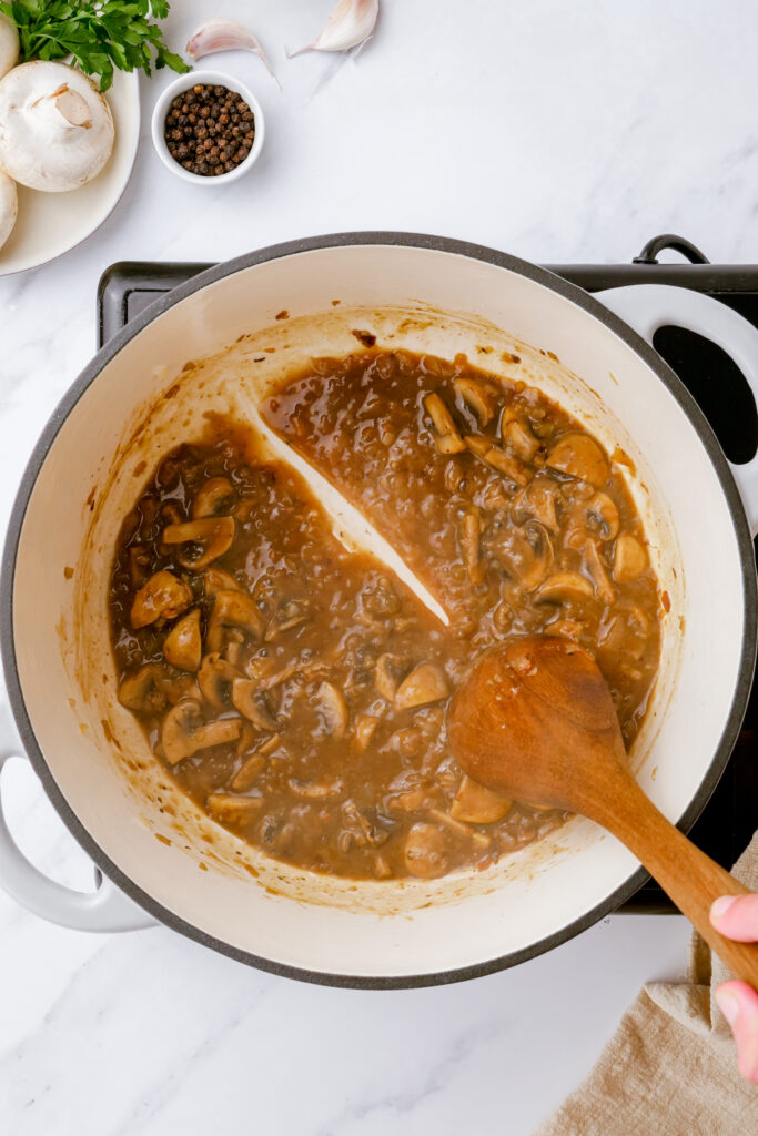 Adding liquid to your chicken fricassee sauce in a dutch oven