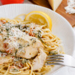 A plate of instant pot pressure cooker tuscan chicken on a bed of pasta