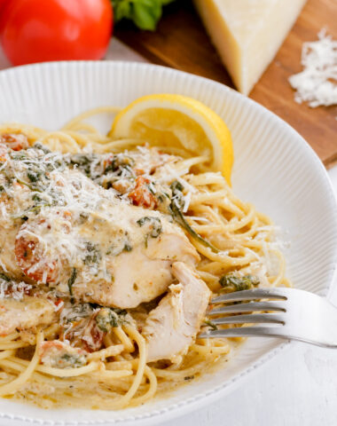 A plate of instant pot pressure cooker tuscan chicken on a bed of pasta