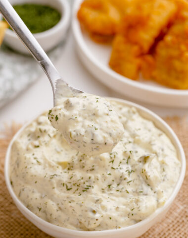 Homemade tartar sauce in a bowl being spooned out to go with fish and chips