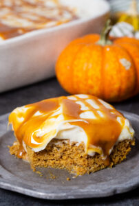 a delicious pumpkin poke cake, loaded with creamy frosting and caramel sauce