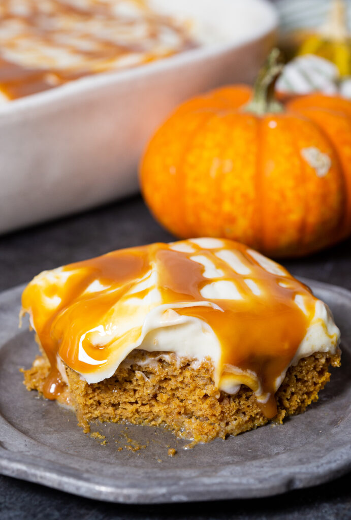 a delicious pumpkin poke cake, loaded with creamy frosting and caramel sauce