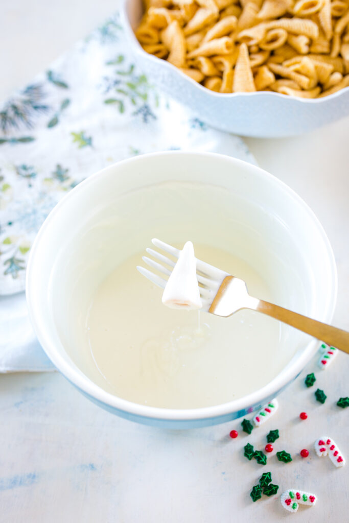 Dipping bugles in white chocolate to make Christmas treats