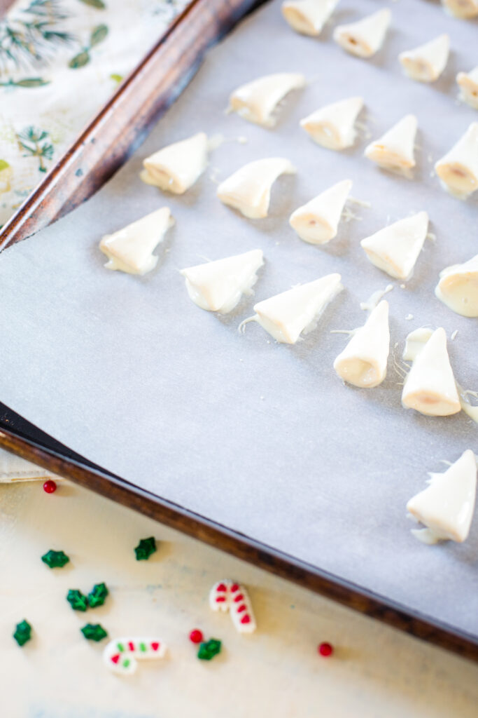 Making Christmas treats, dipping bugles in white chocolate