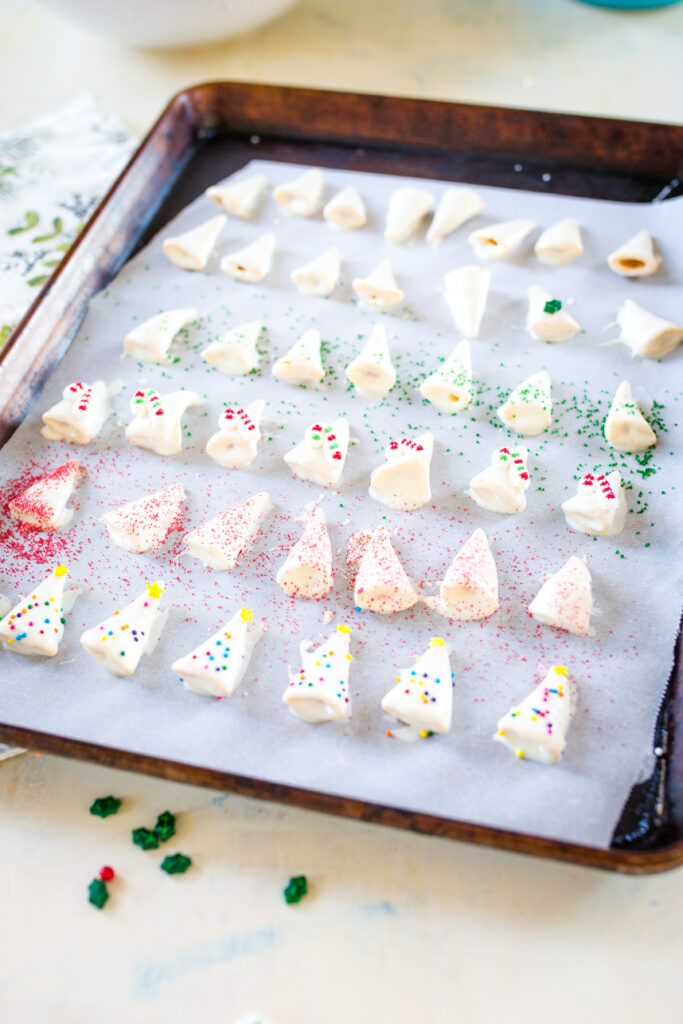 Making Christmas treats by dipping bugles in white chocolate 