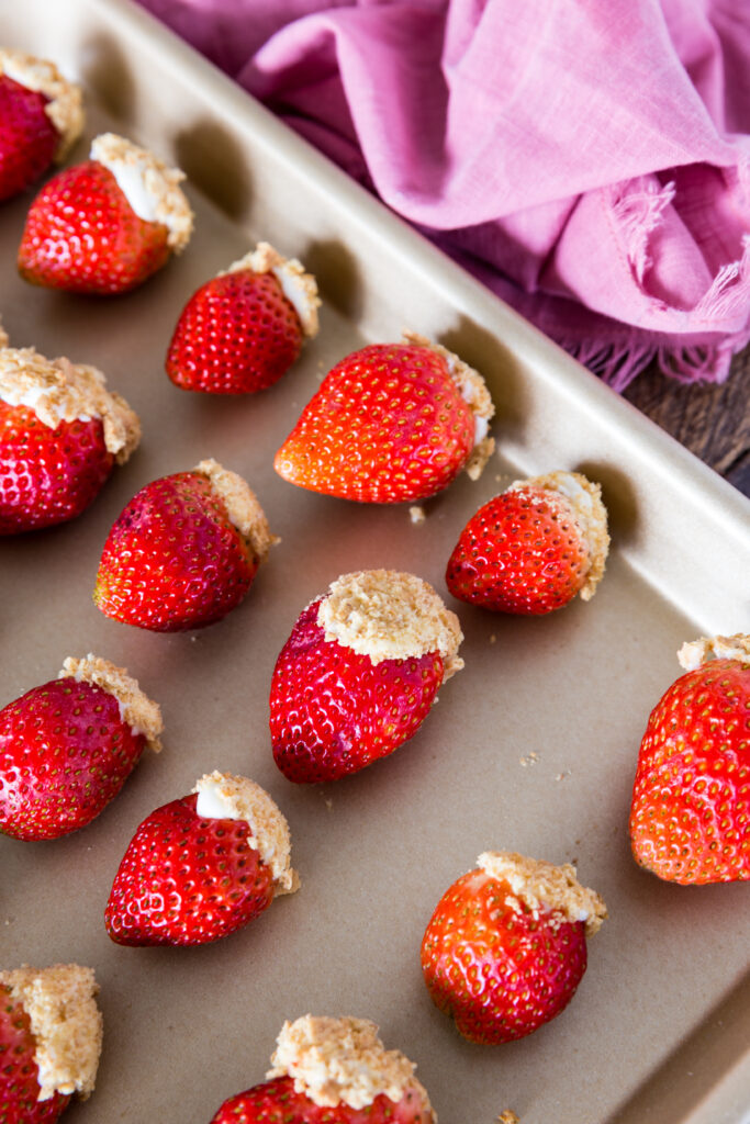 Cheesecake stuffed strawberries on a tray. 