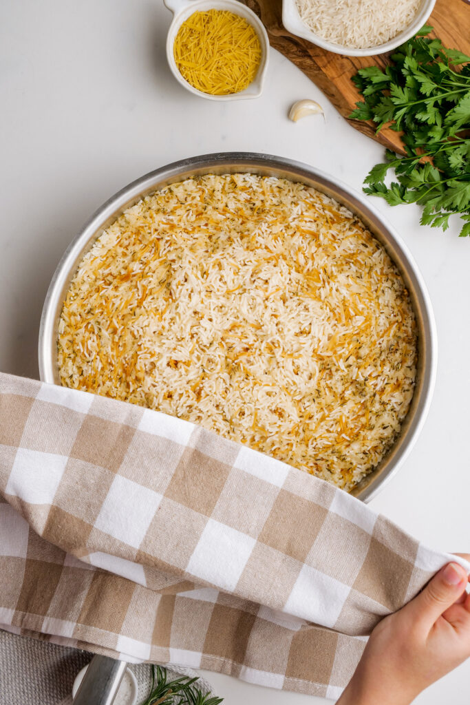 Herbed Rice Pilaf: Putting a dish towel over your rice pilaf to let it absorb water so it will be fluffy and delicious