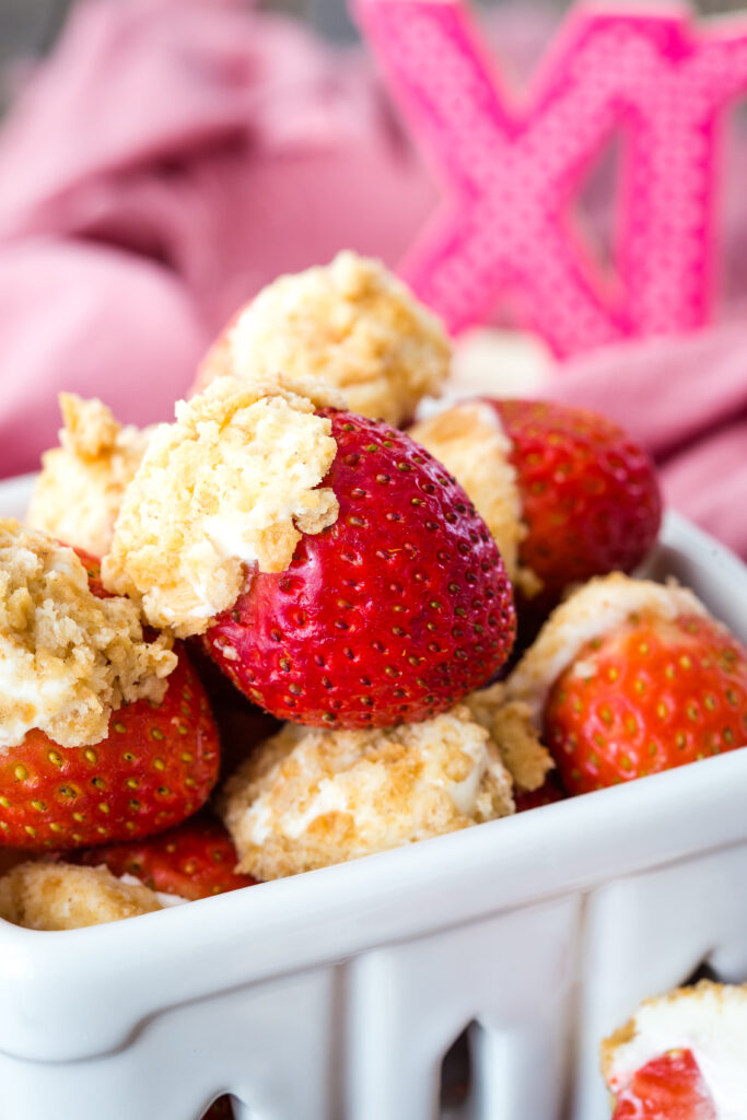 A container full of cheesecake stuffed strawberries