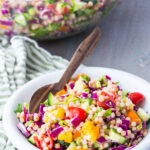 A bowl of couscous salad with tons of fresh herbs and veggies