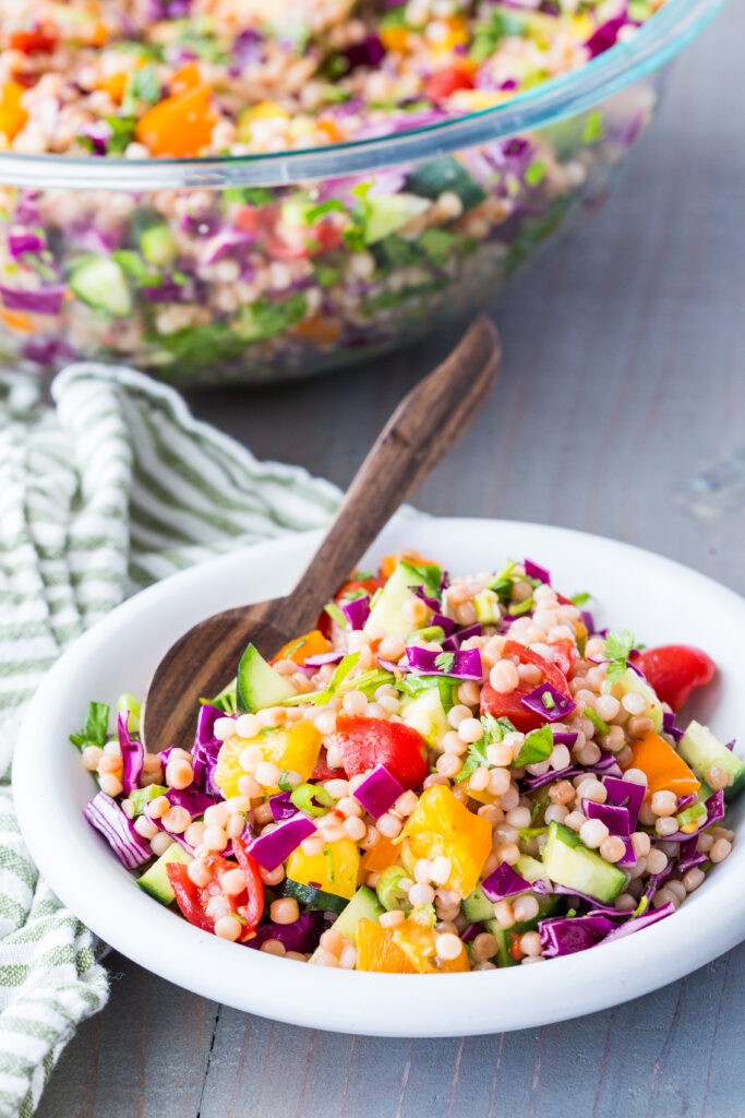 A bowl of couscous salad with tons of fresh herbs and veggies