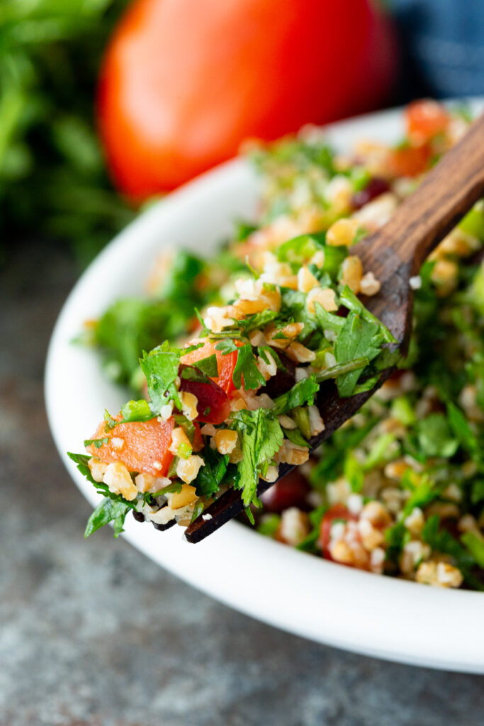 A fork full of tabbouleh, a fresh herb israeli salad with bulgur