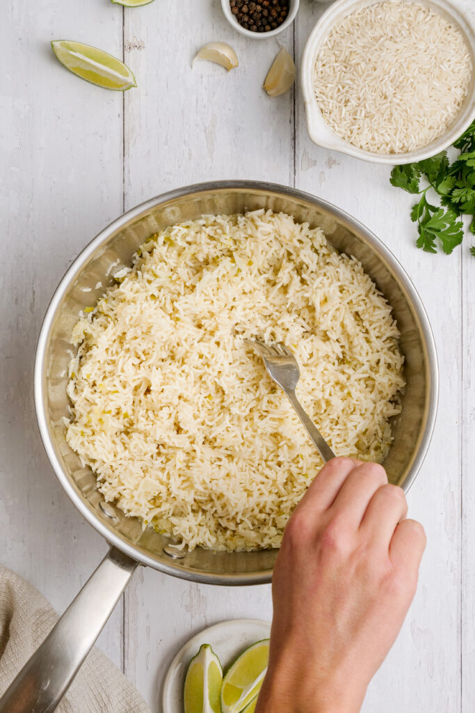 Fluff the rice with fork to make cilantro lime rice.