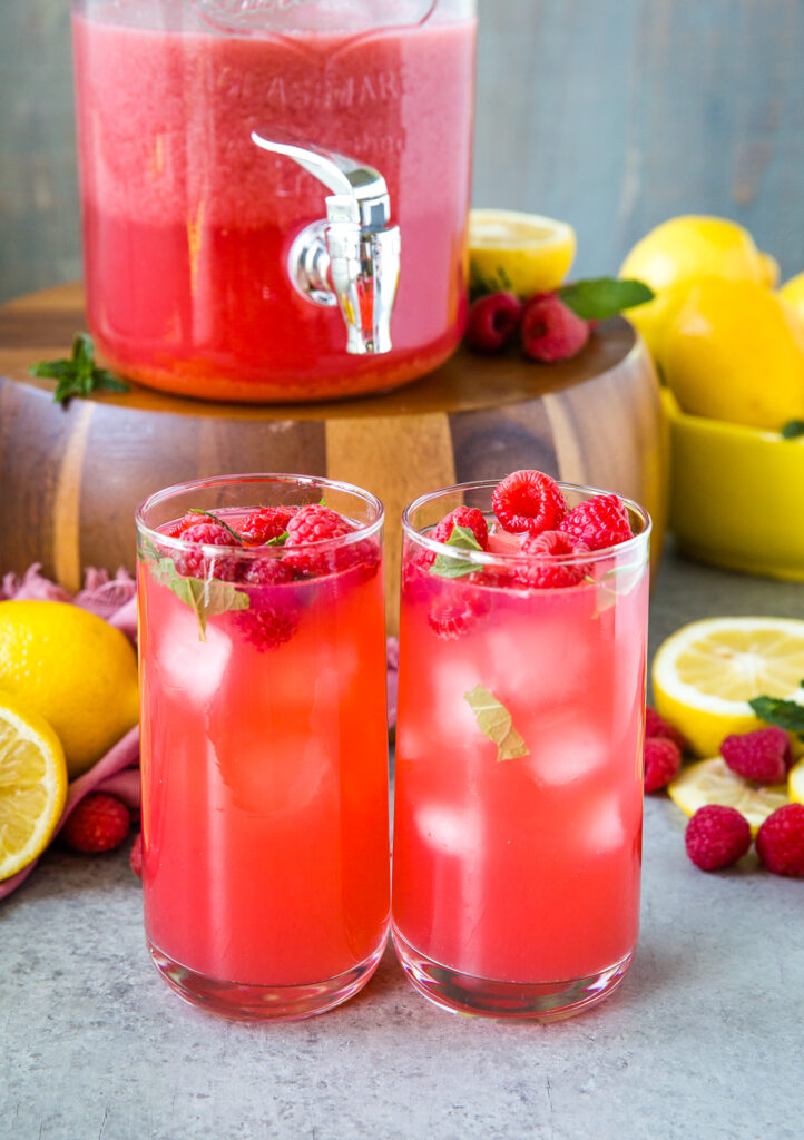 A pitcher and two glasses of raspberry lemonade