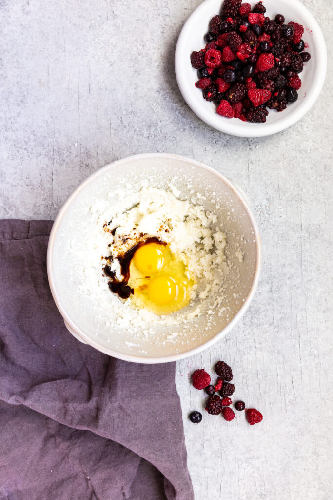 Adding the eggs and vanilla in to triple berry muffins