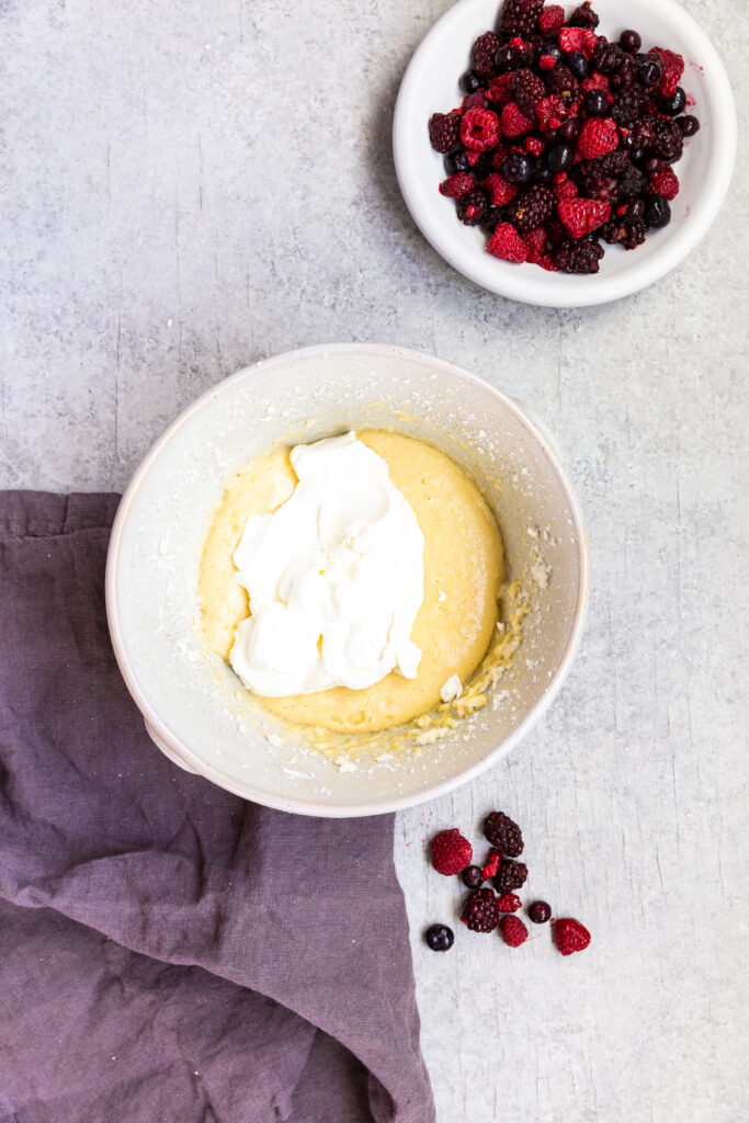 Adding sour cream to triple berry muffins to make them moist