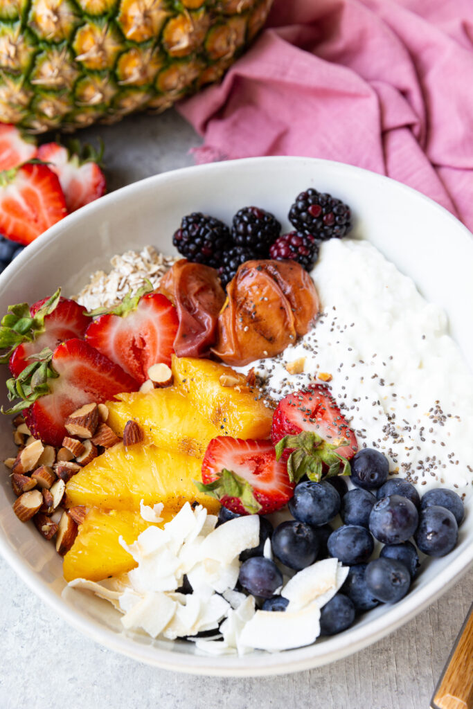 A breakfast bowl made up of high protein cottage cheese and fruits, nuts, seeds. 