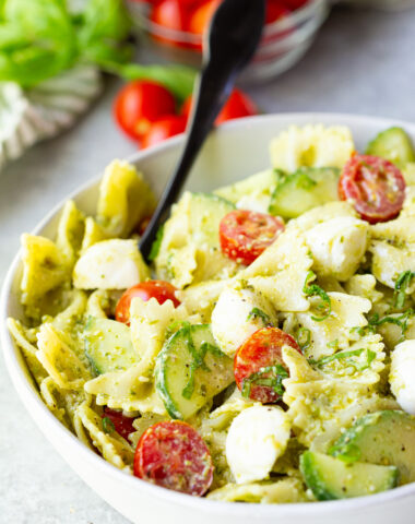 Pesto Pasta Salad with bowtie pasta, fresh tomatoes and cucumbers, and mozzarella cheese.