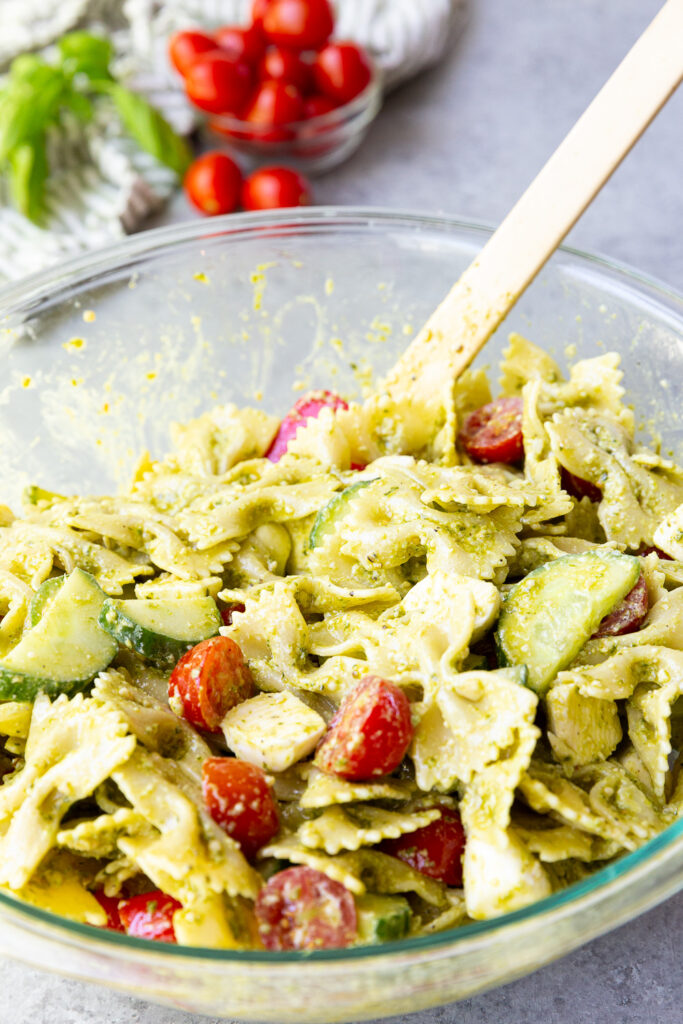 Making a pesto pasta salad with mozzarella cheese