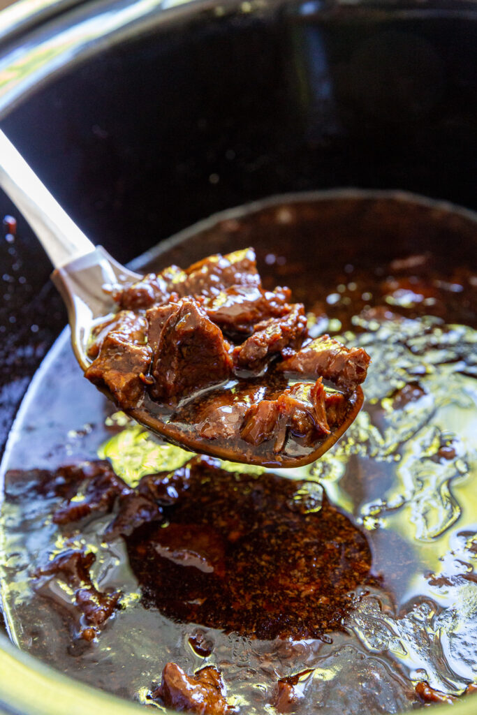 Finished cooking slow cooker teriyaki beef with a homemade teriyaki sauce