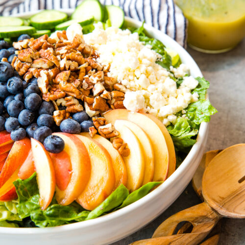 Peach berry summer salad in a white bowl