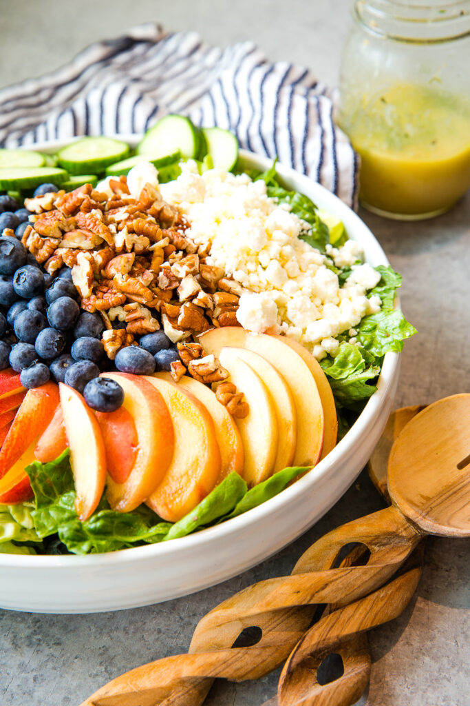 Peach berry summer salad in a white bowl