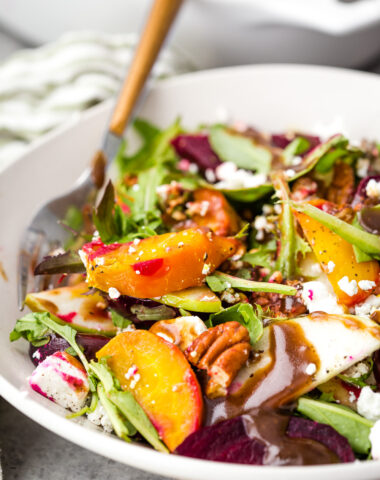 A cozy fall beet salad with mixed greens, goat cheese, two kinds of beets, and toasted pecans.